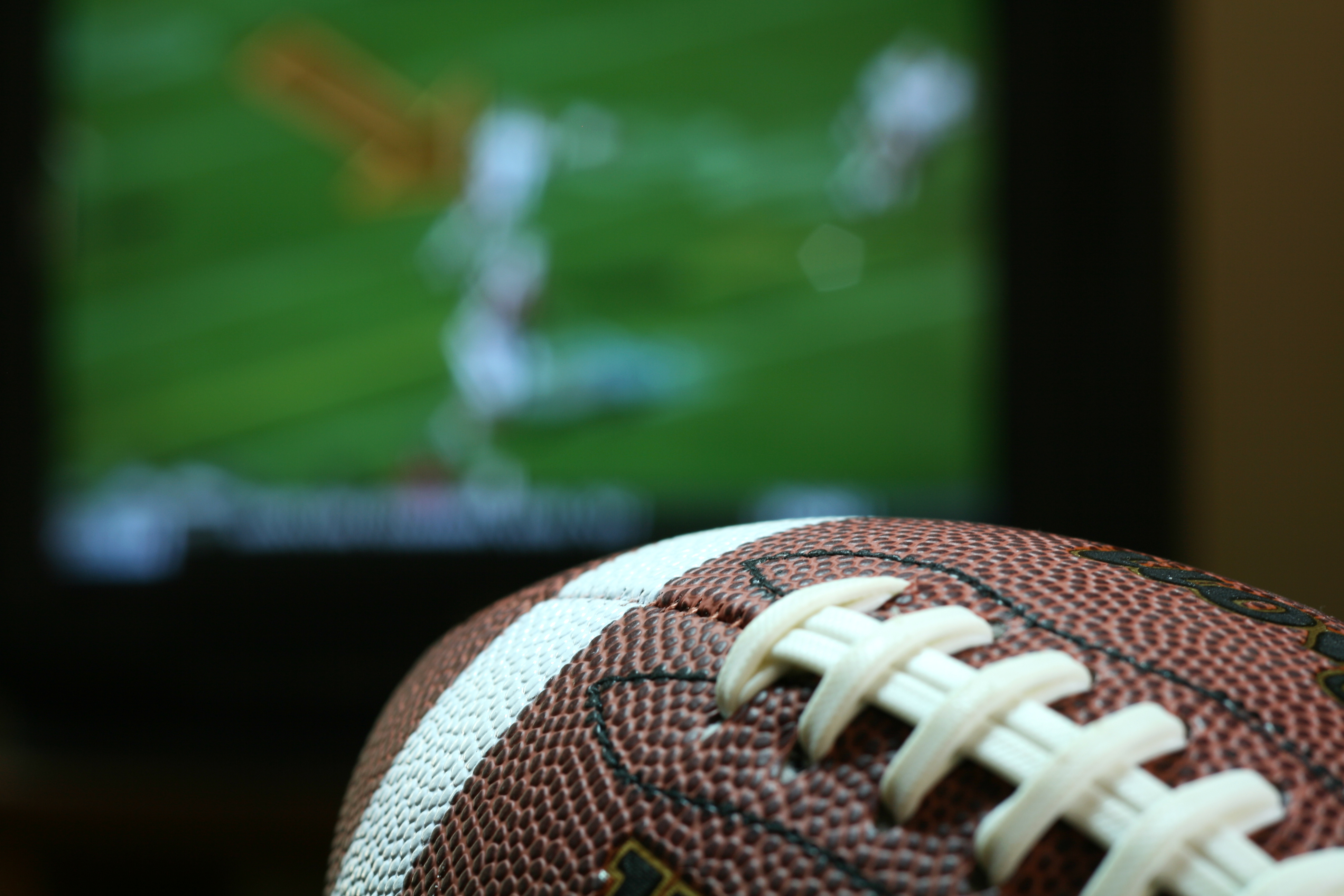 football fan holds a football while watching the game